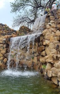 bioconstrucción de cascada de piedra y paisajismo.